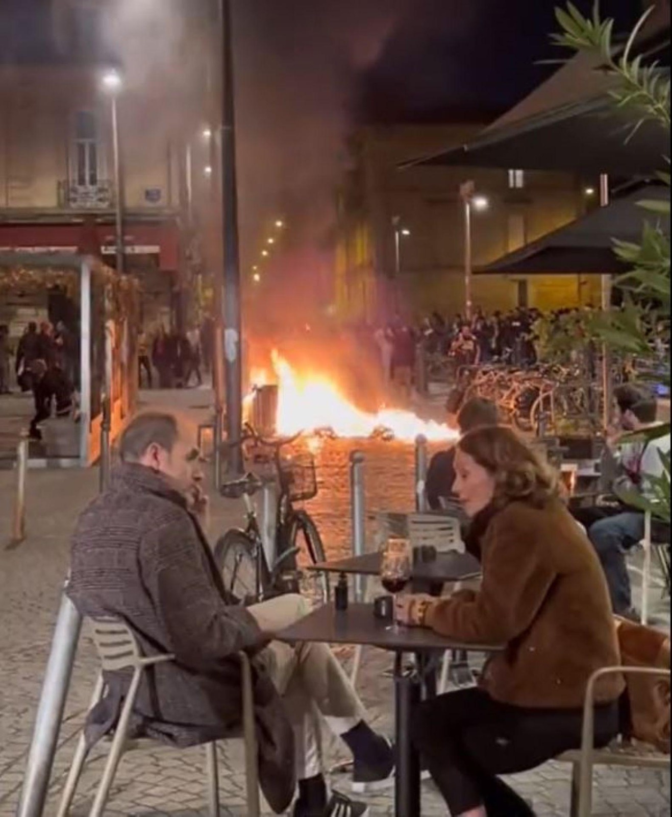 Couple Enjoys a Drink at Paris Cafe as Fire Burns Nearby, Video Goes Viral